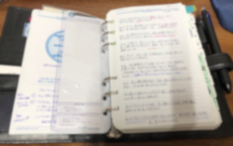 手書きのメモが書き込まれた、開いたシステム手帳。